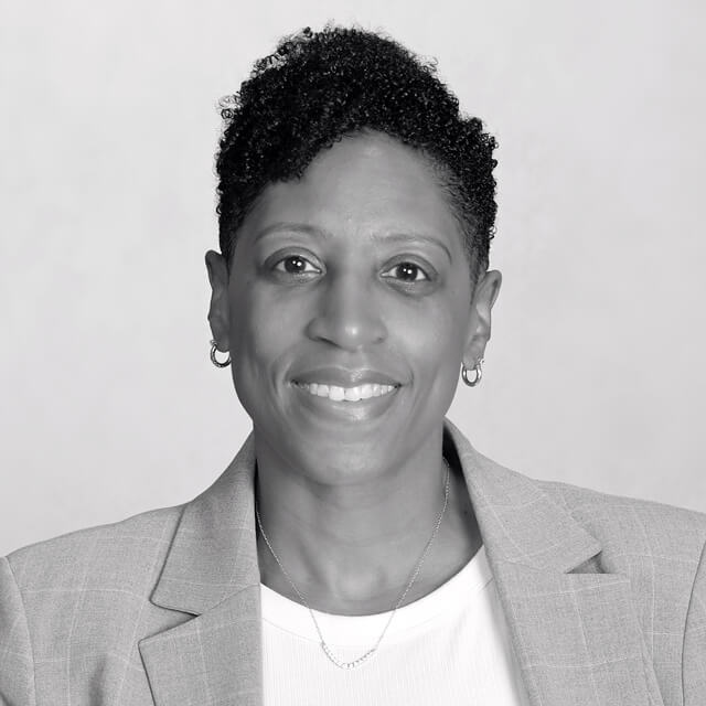 Photo of Yvette wearing a blazer, smiling at the camera