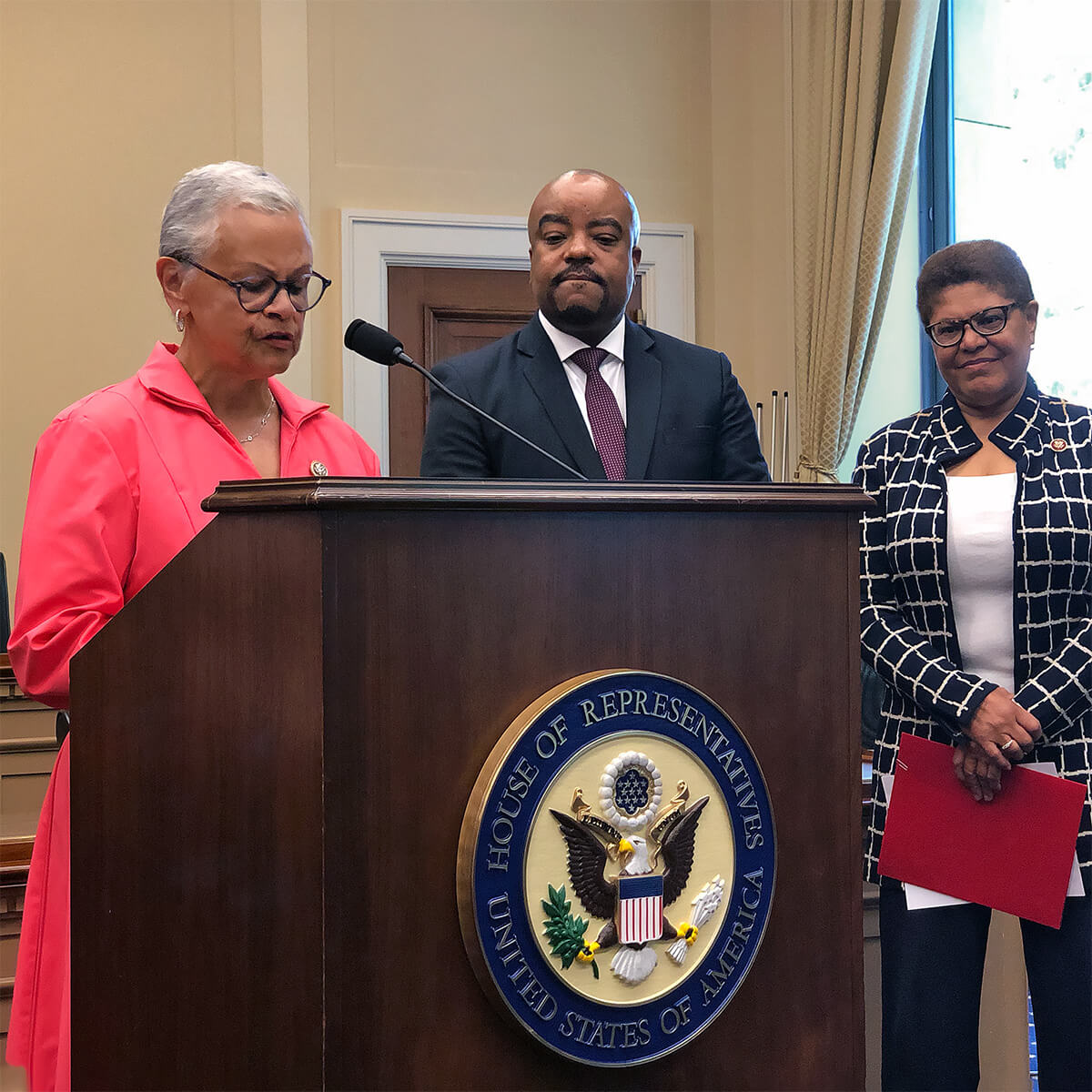 Rep. Bonnie Watson Coleman speaking while Dr. Michael A. Lindsey Rep. Karen Bass look on in 2019.