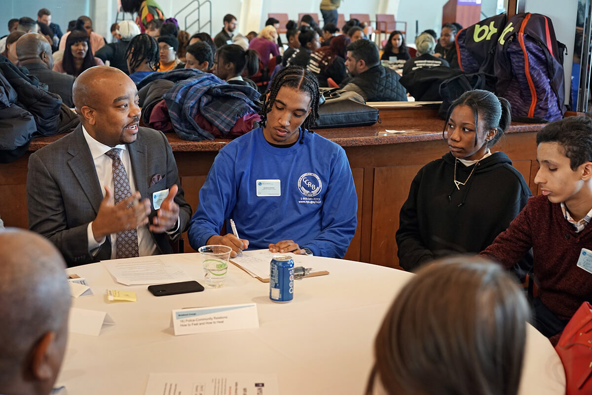 Dr. Lindsey sitting at a round table with young people