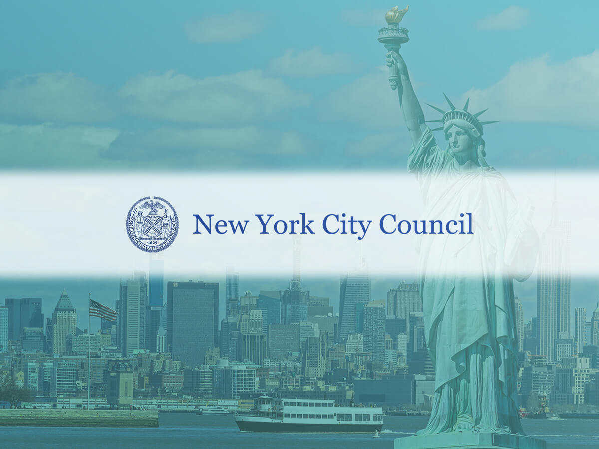 The NYC Council wordmark displayed over a cityscape prominently featuring the statue of liberty.