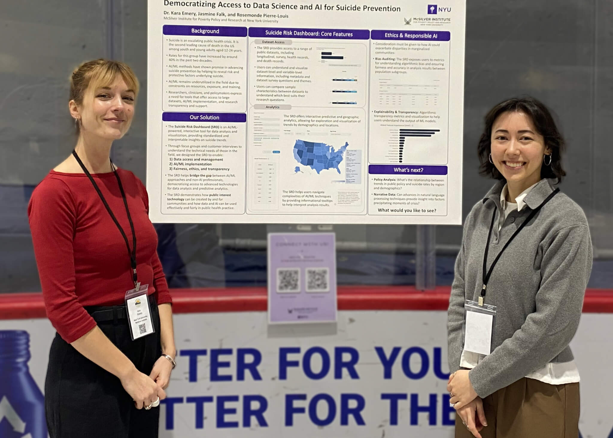 Two women standing, smiling in front of a poster detailing scientific findings.